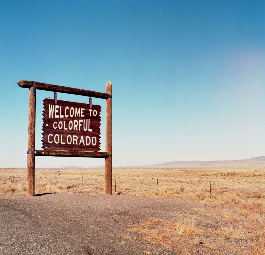 A wooden sign welcoming to Colorado
